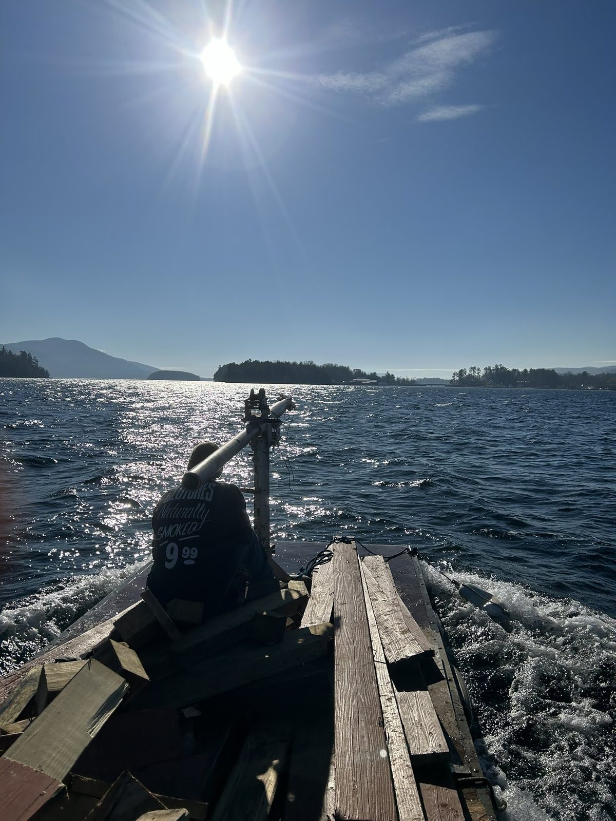 Barge crossing open water with the Lake George mountains beyond