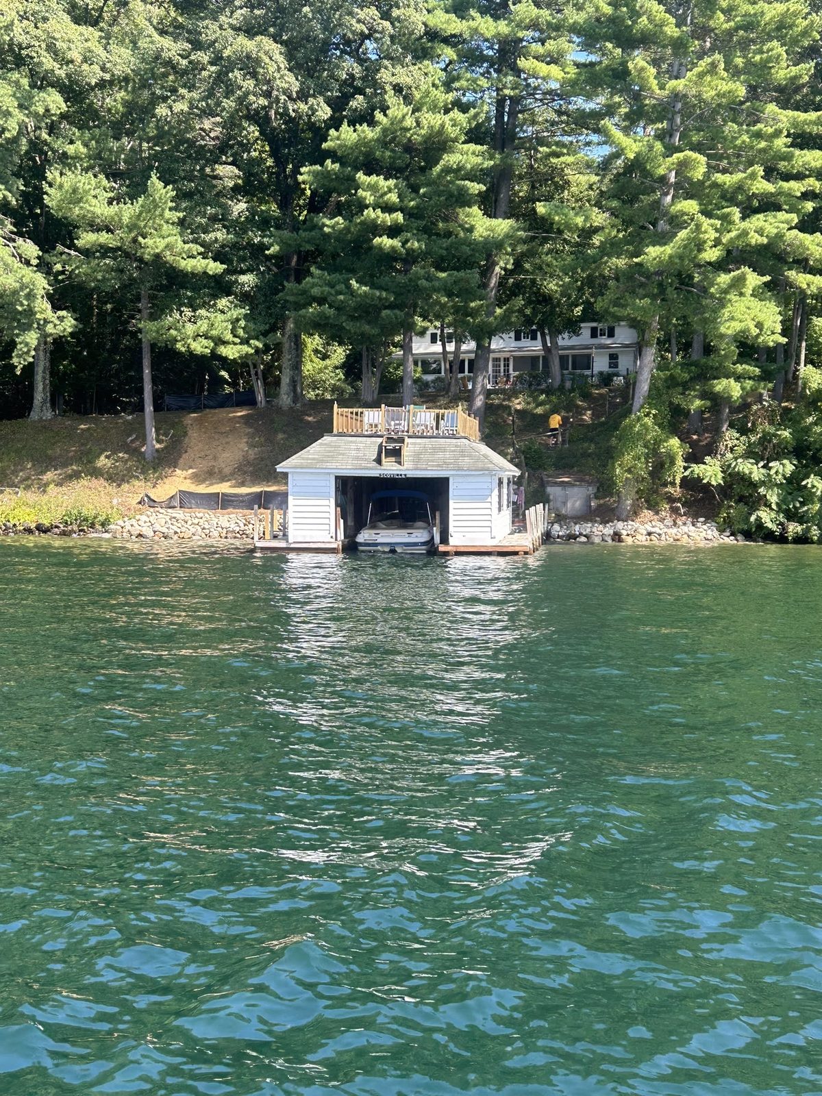 Boathouse viewed across clear turquoise Lake George water