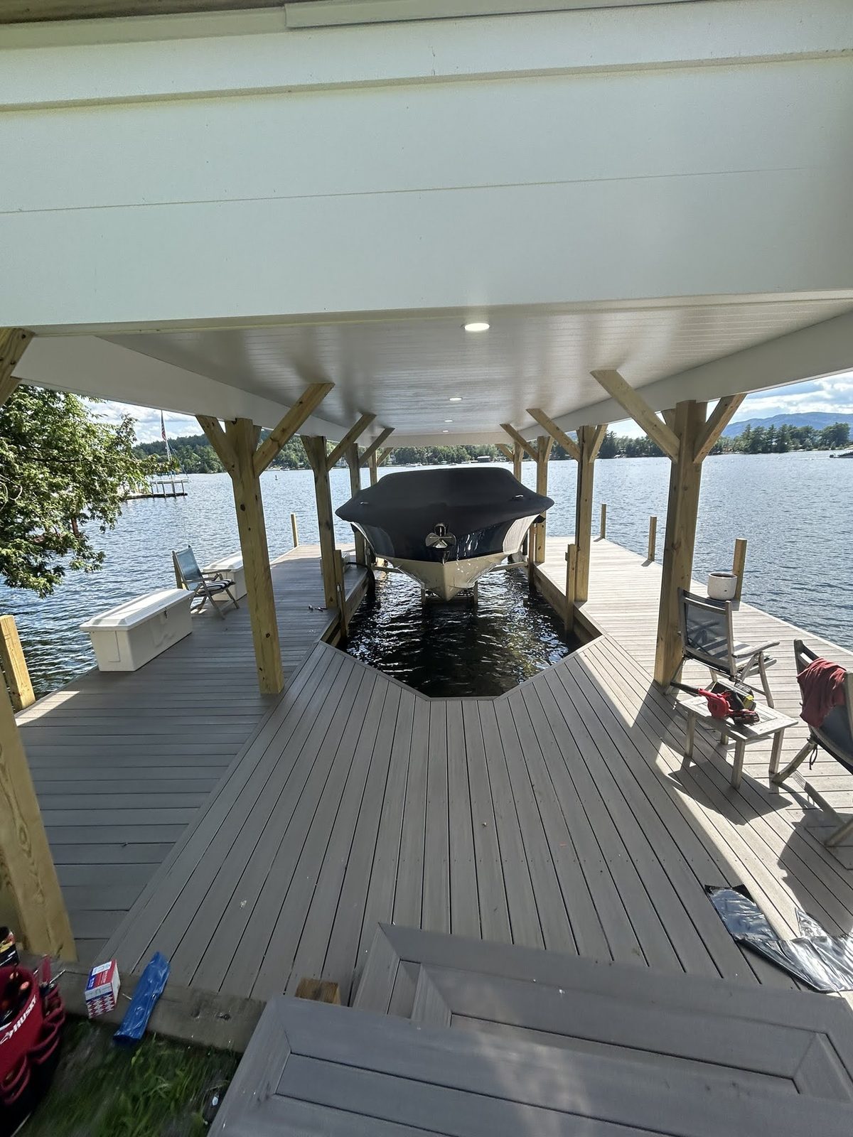 Boathouse interior with boat on a lift under a covered slip