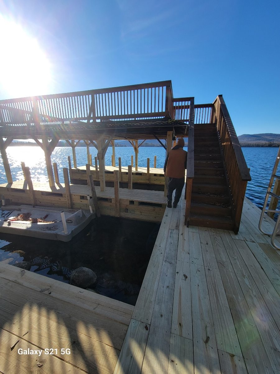 New boathouse sundeck with stairs and railing overlooking the lake