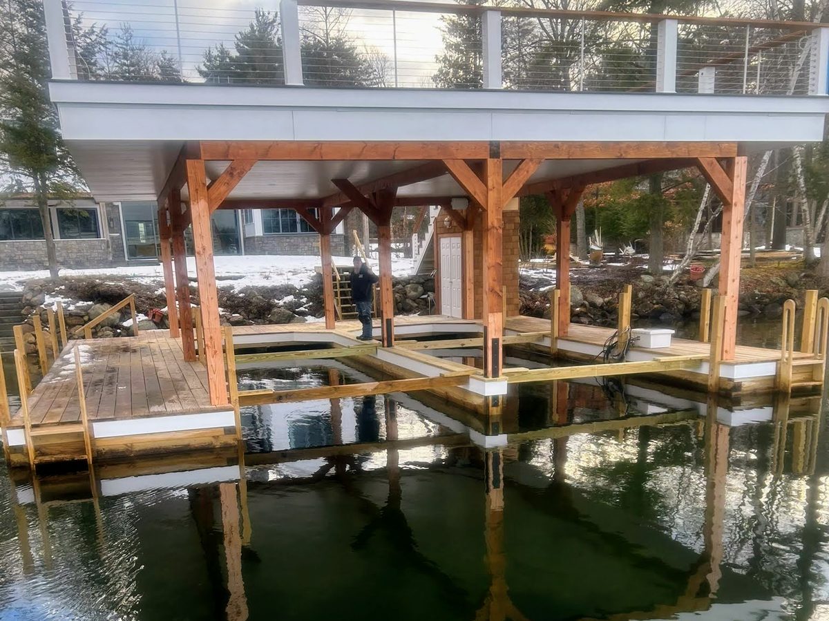 New timber-frame boathouse structure rising above the ice line