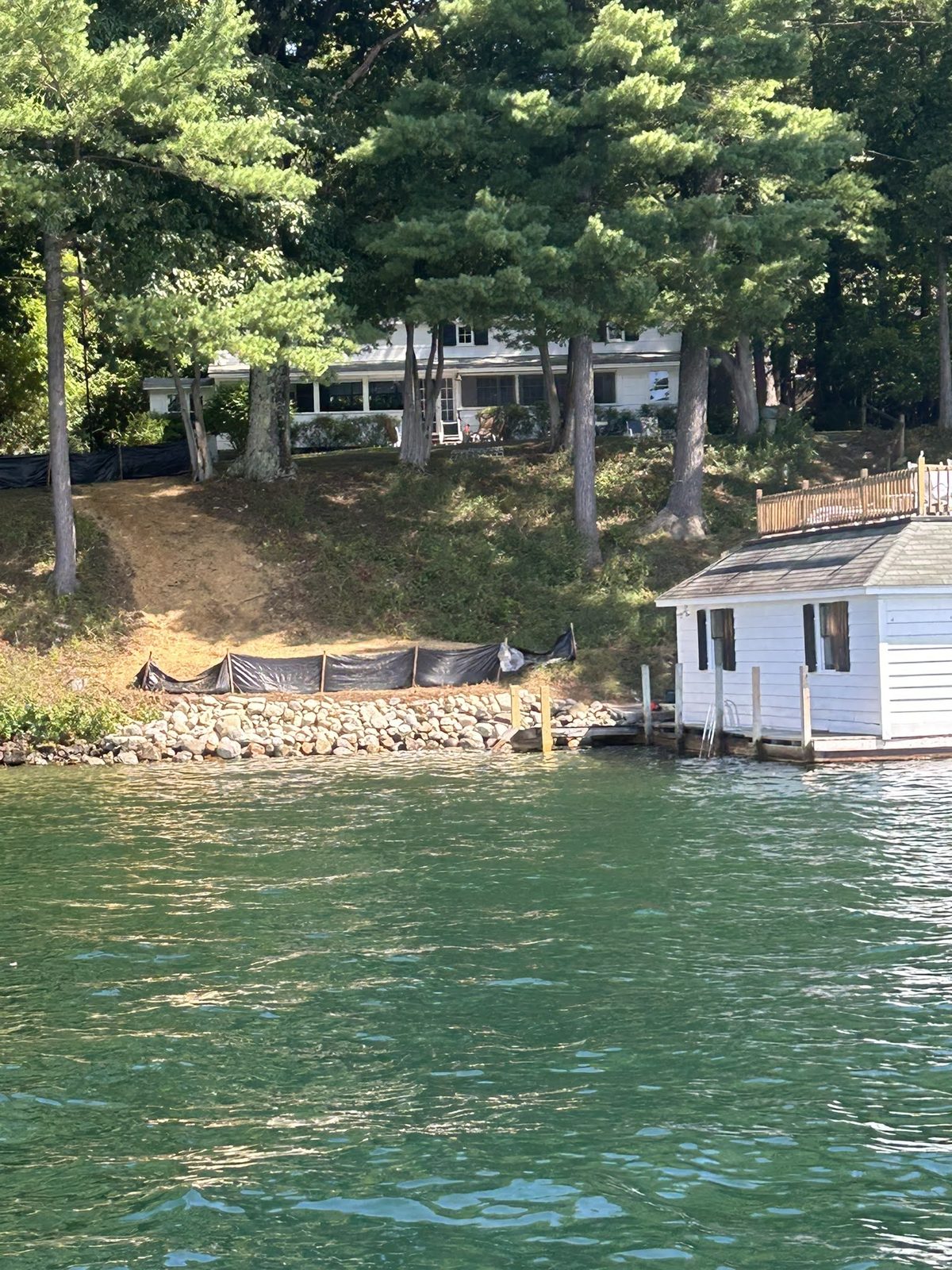 White boathouse set into a restored stone shoreline