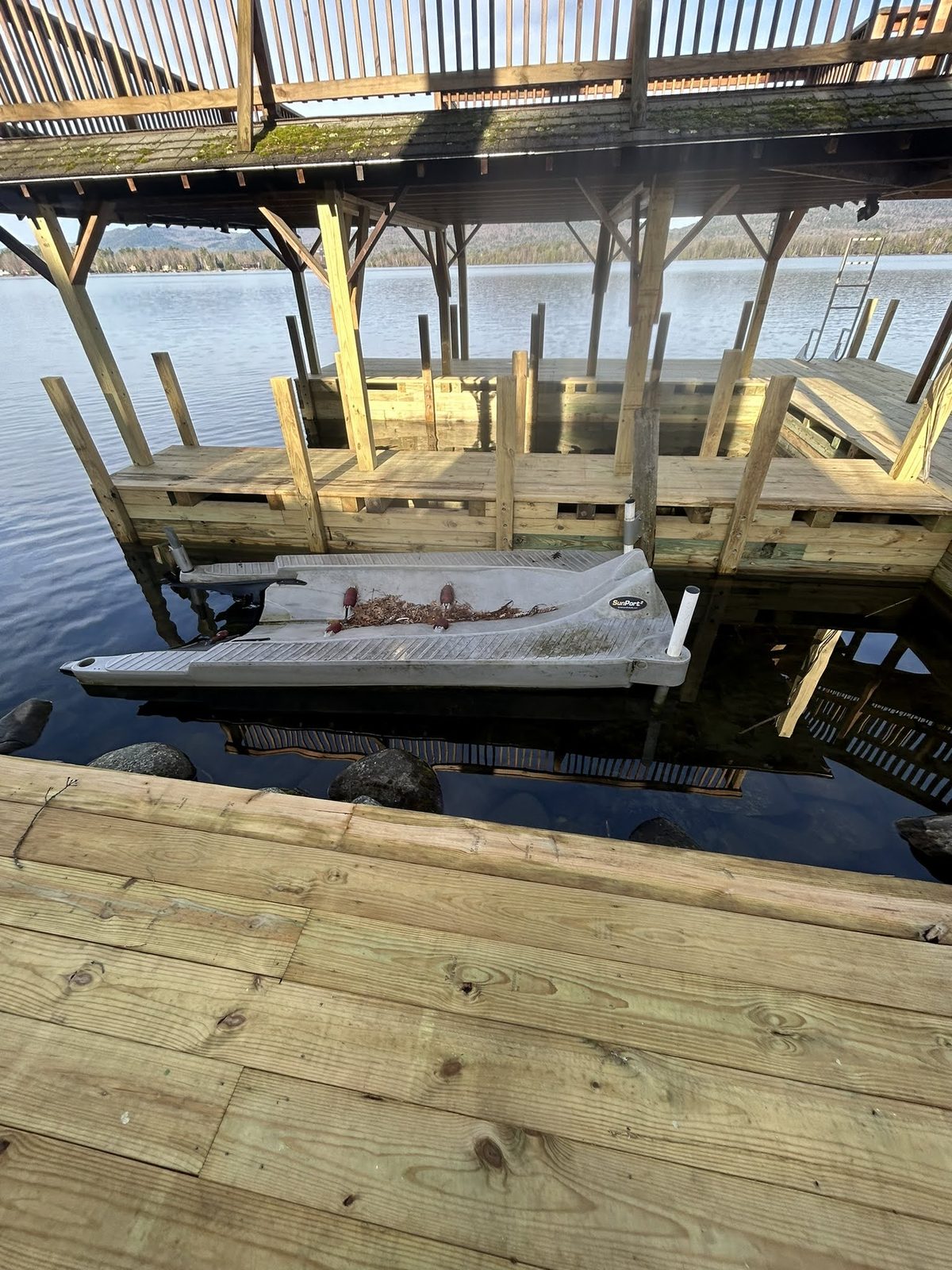Boat lift installation beneath a covered Lake George slip