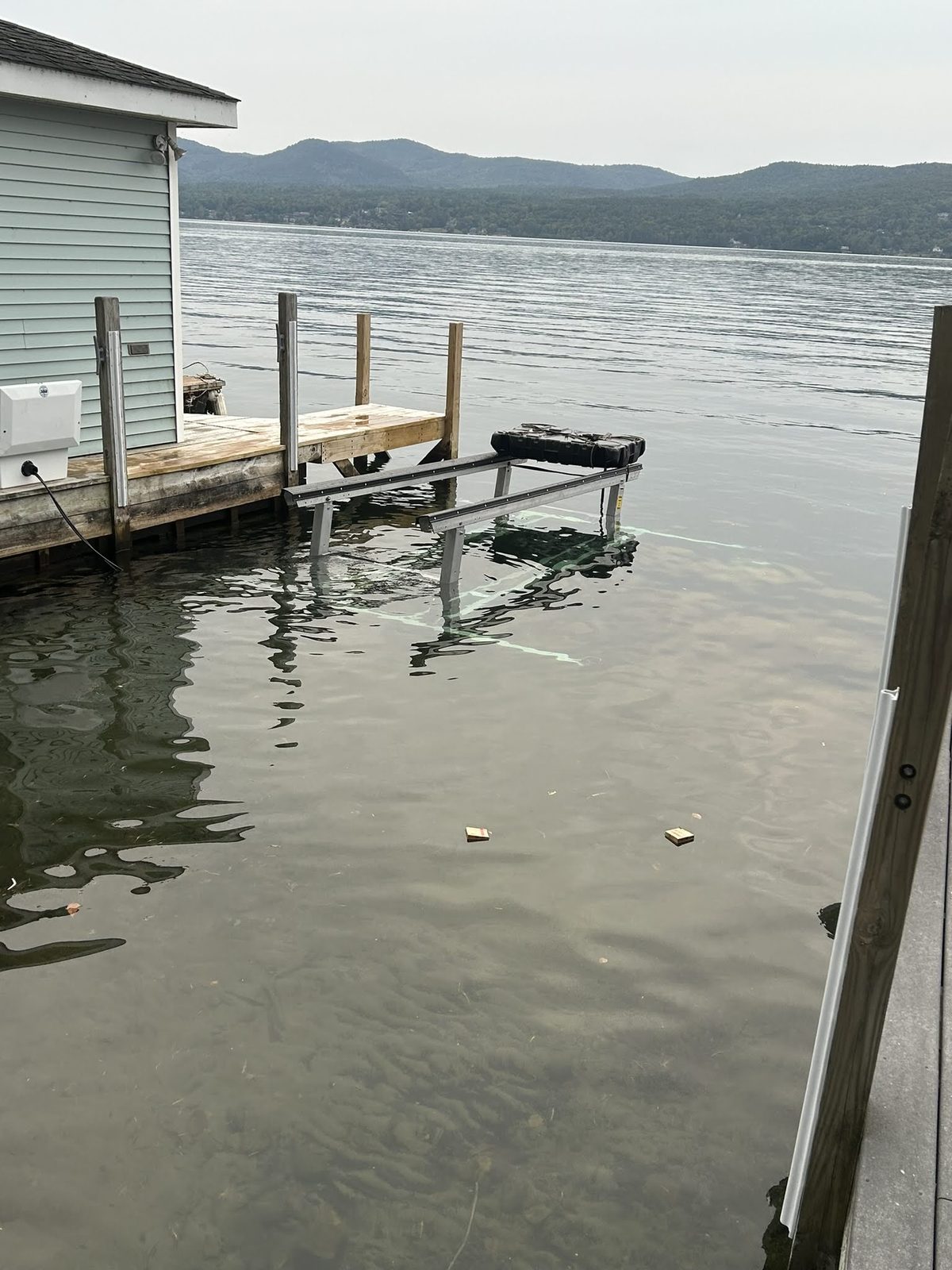 Boat lift installed alongside a dock at a Lake George boathouse