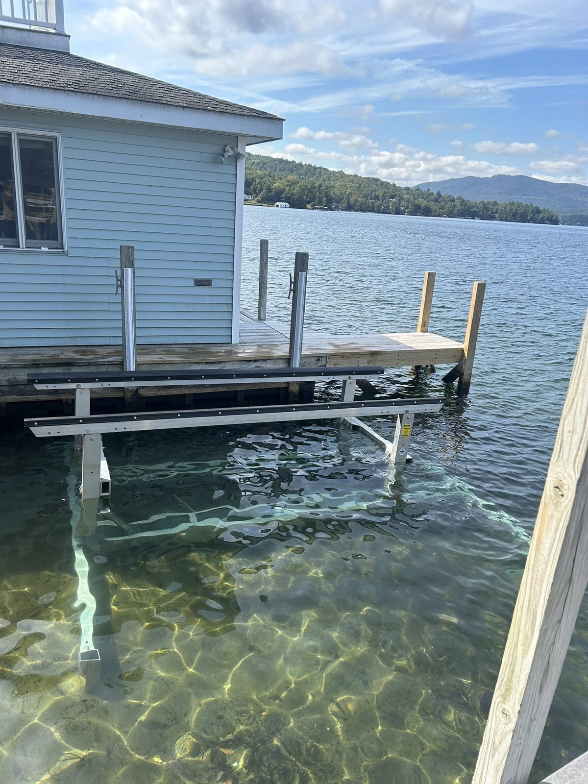 Boat lift set beside a boathouse with mountain views