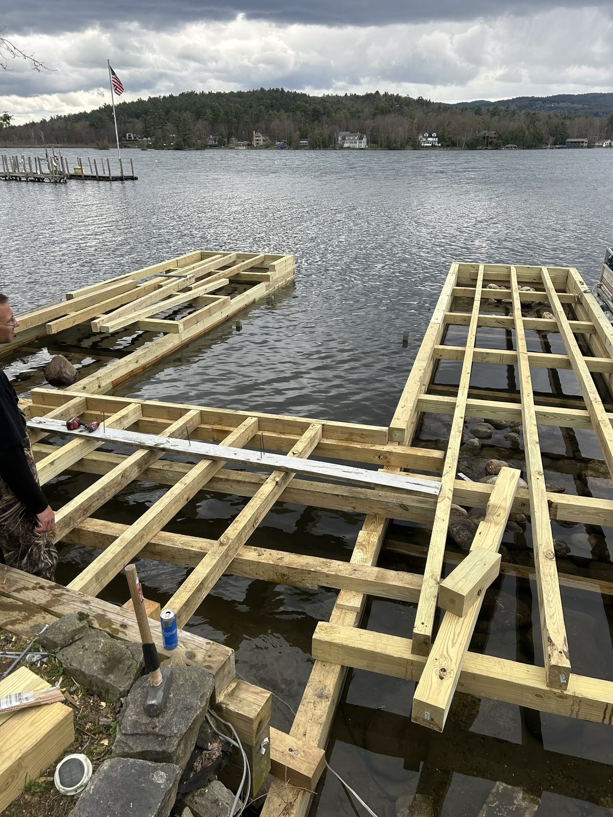 Pressure-treated dock frame staged at the water's edge