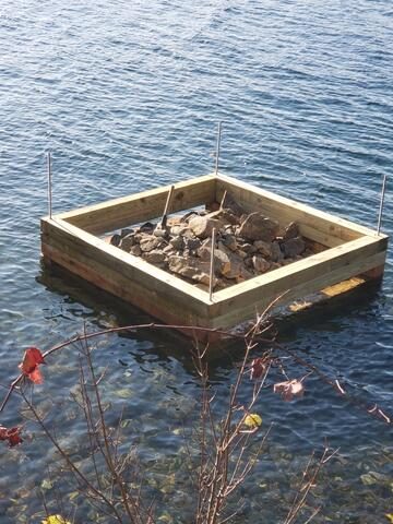 Rock-filled crib floating in position before it is set on the lake bottom