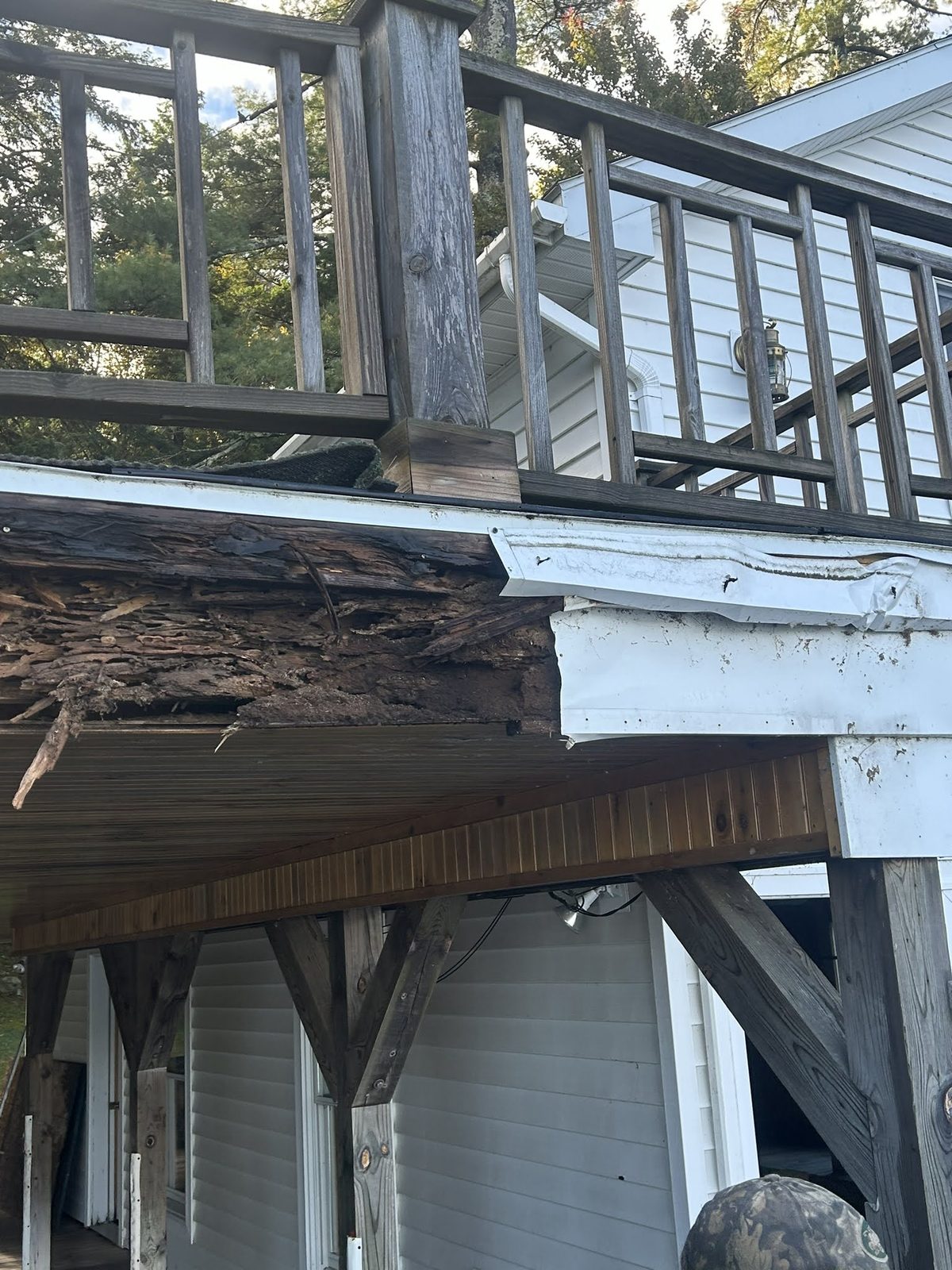 Close view of rot damage where a deck meets the house wall