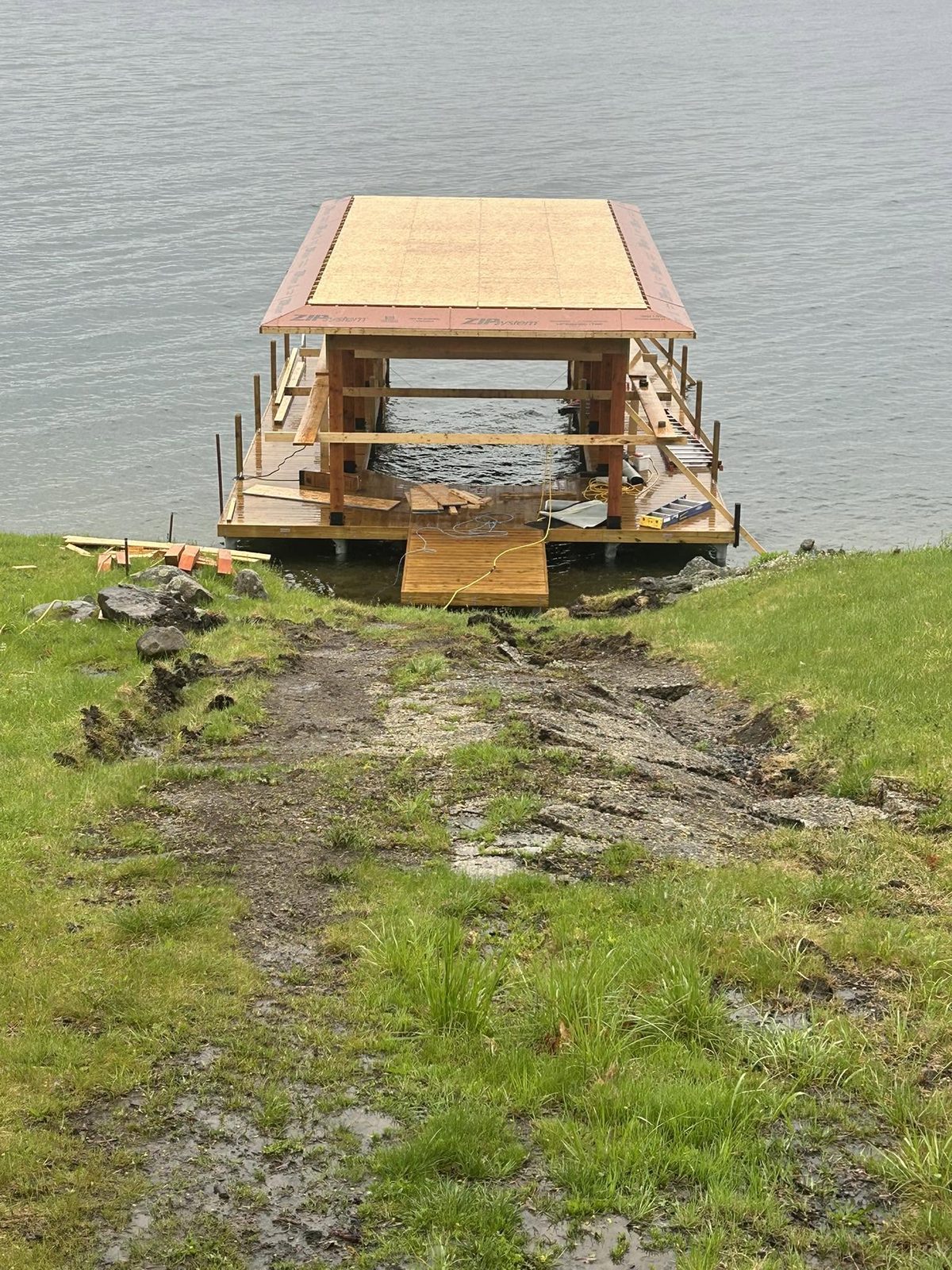 Completed Douglas fir post-and-beam boathouse with sundeck, viewed from the water