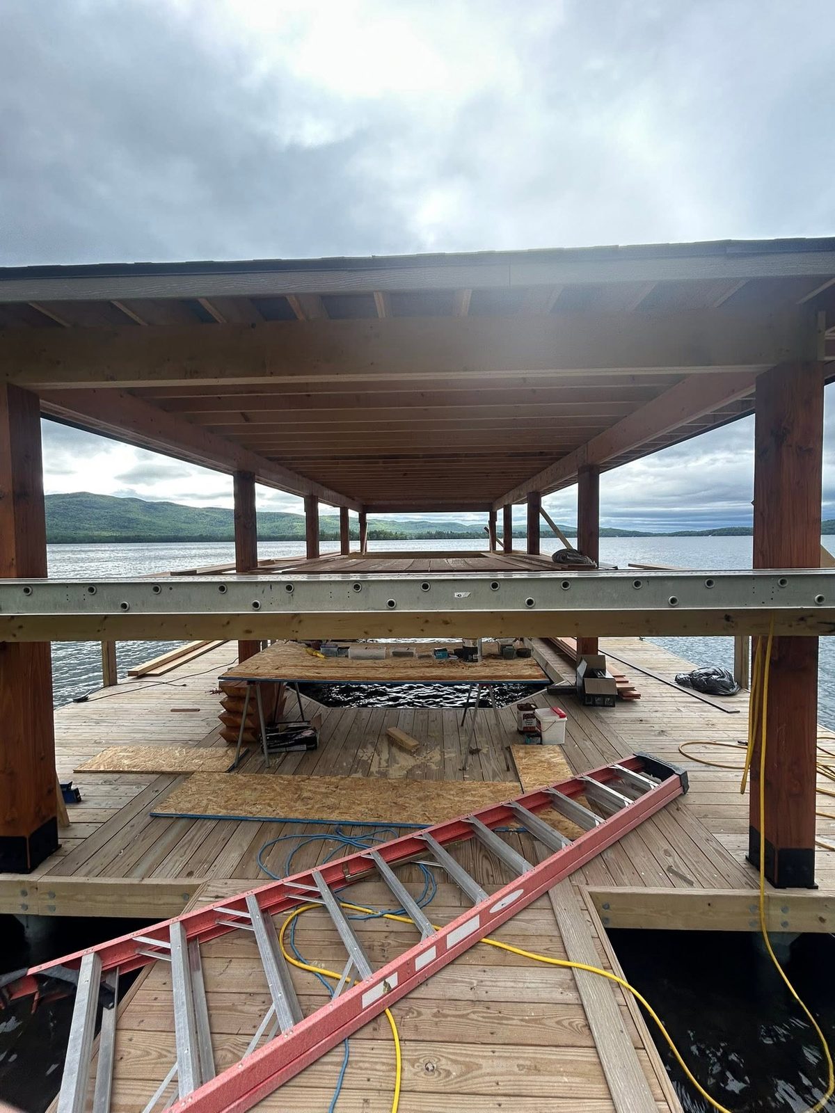 Douglas fir post-and-beam boathouse under construction over Lake George