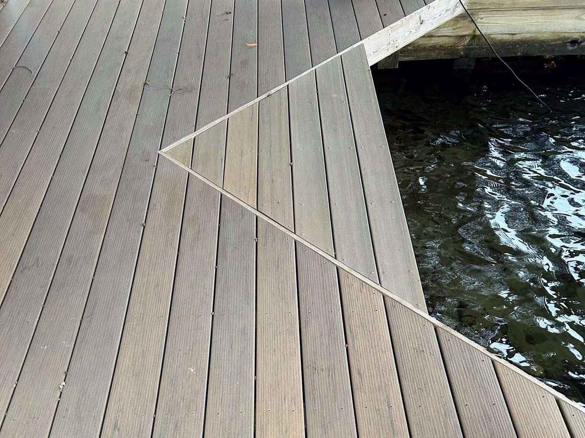 Angled composite dock decking detail over dark lake water