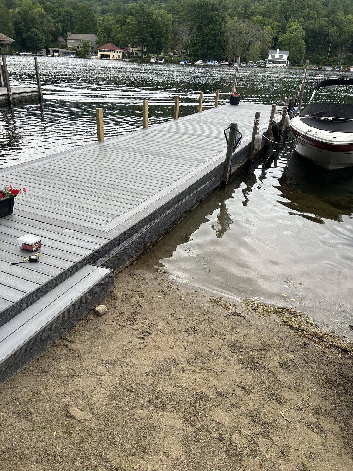 Composite dock meeting a sand beach on the Lake George shoreline