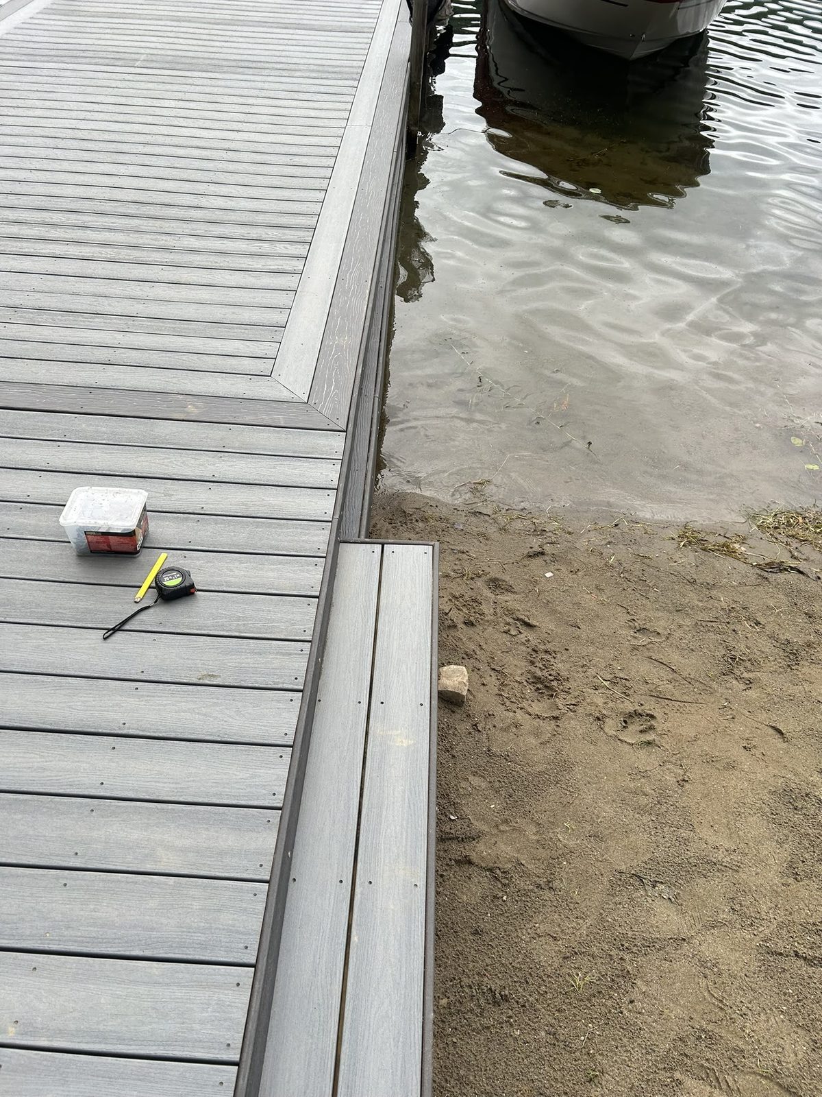 Composite dock decking terminating at a raked sand shoreline