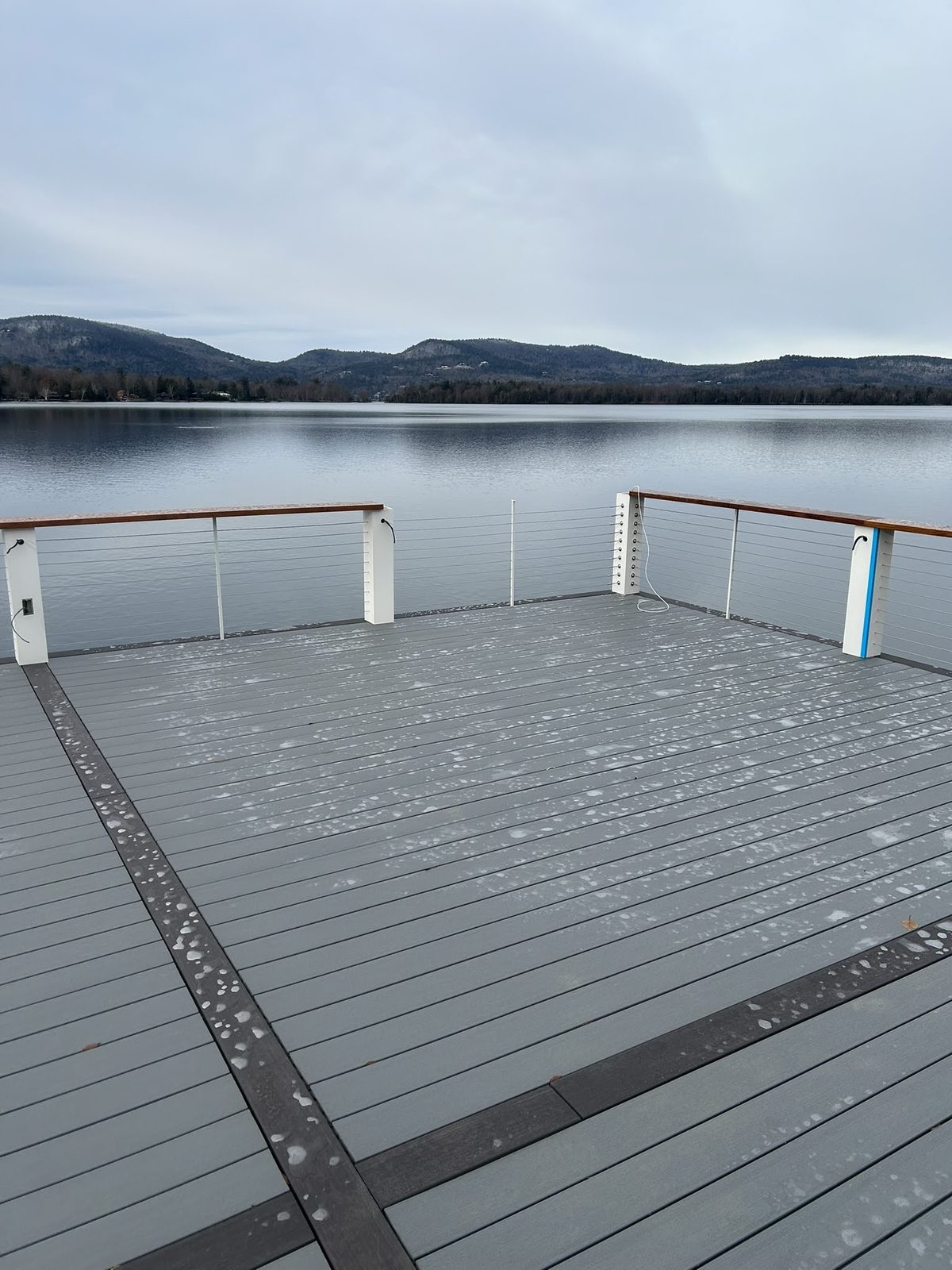 Large gray composite dock platform on a calm Lake George morning