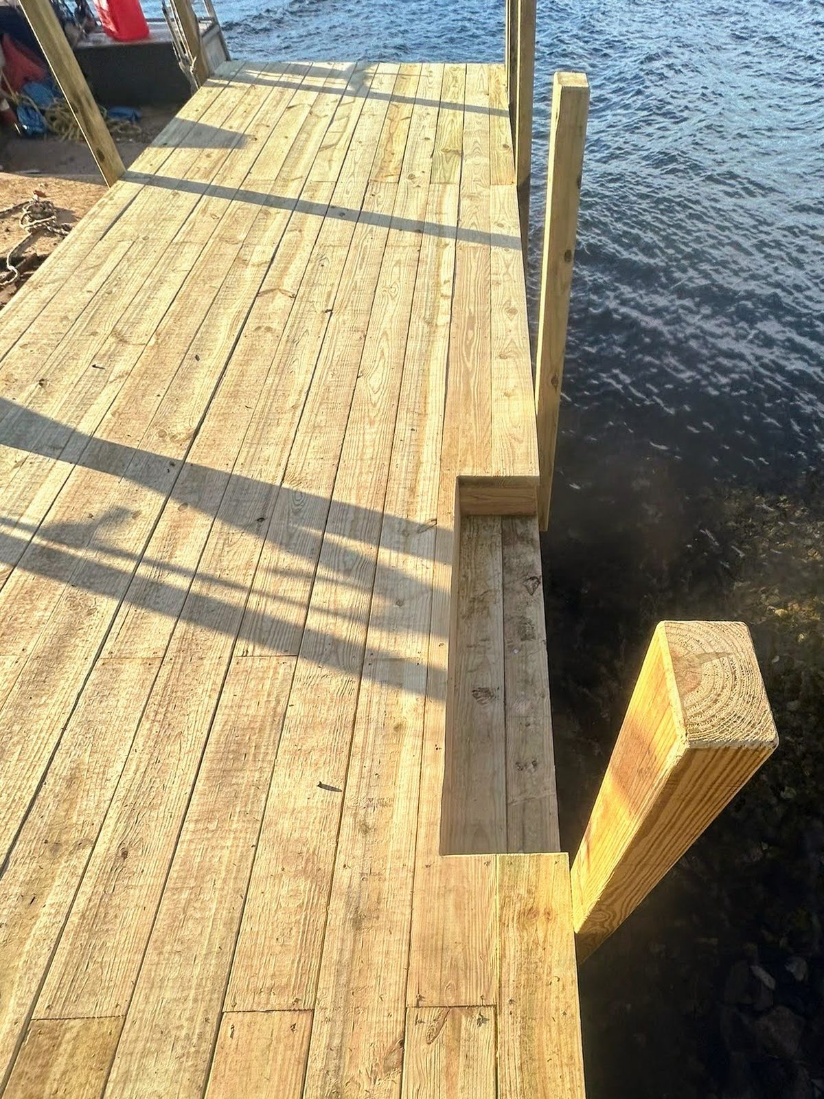 Freshly built cedar dock decking with bracing over Lake George