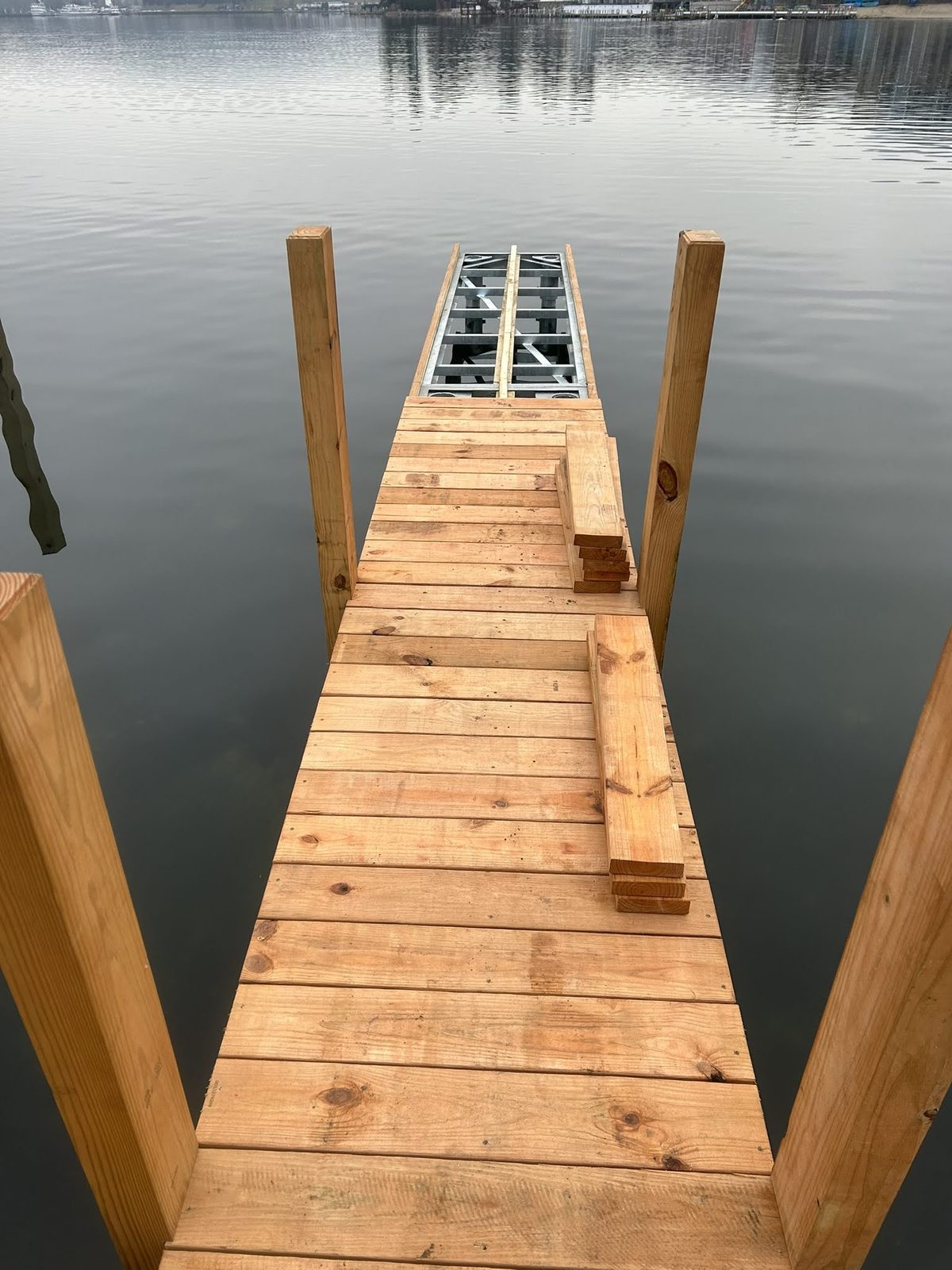 Narrow dock walkway extending over clear Lake George water