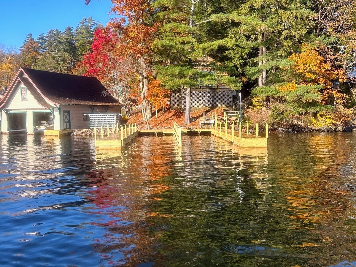 Lakeside boathouse and new dock framed by autumn foliage on Lake George, New York