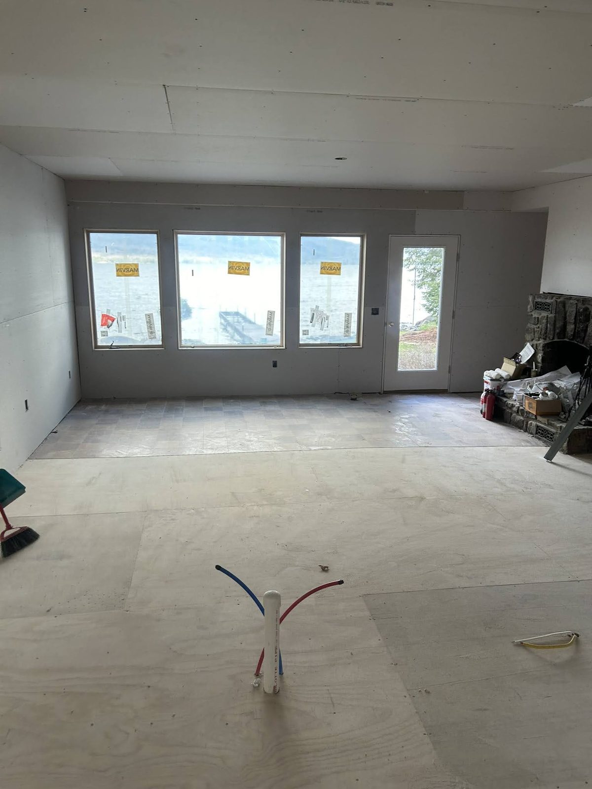 Great room with new windows and lake-facing doors before finishes