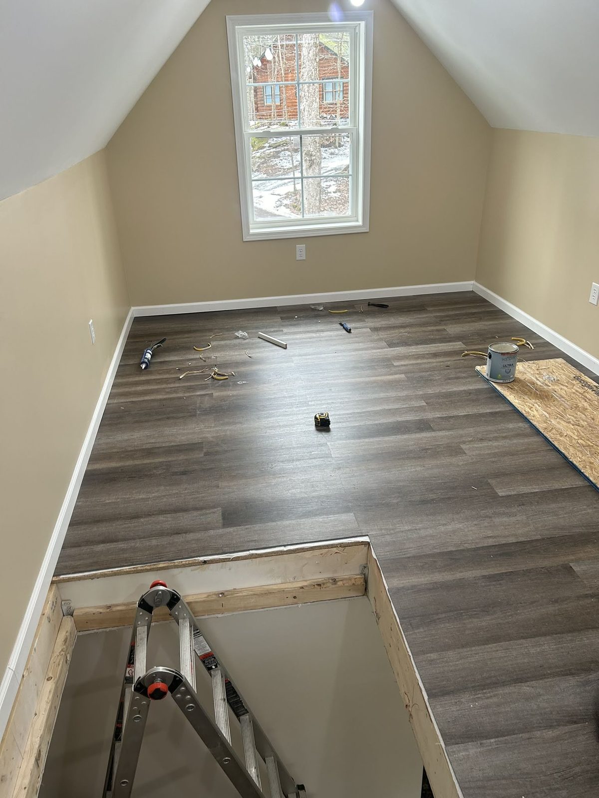 New luxury vinyl plank flooring being installed in a lakeside home