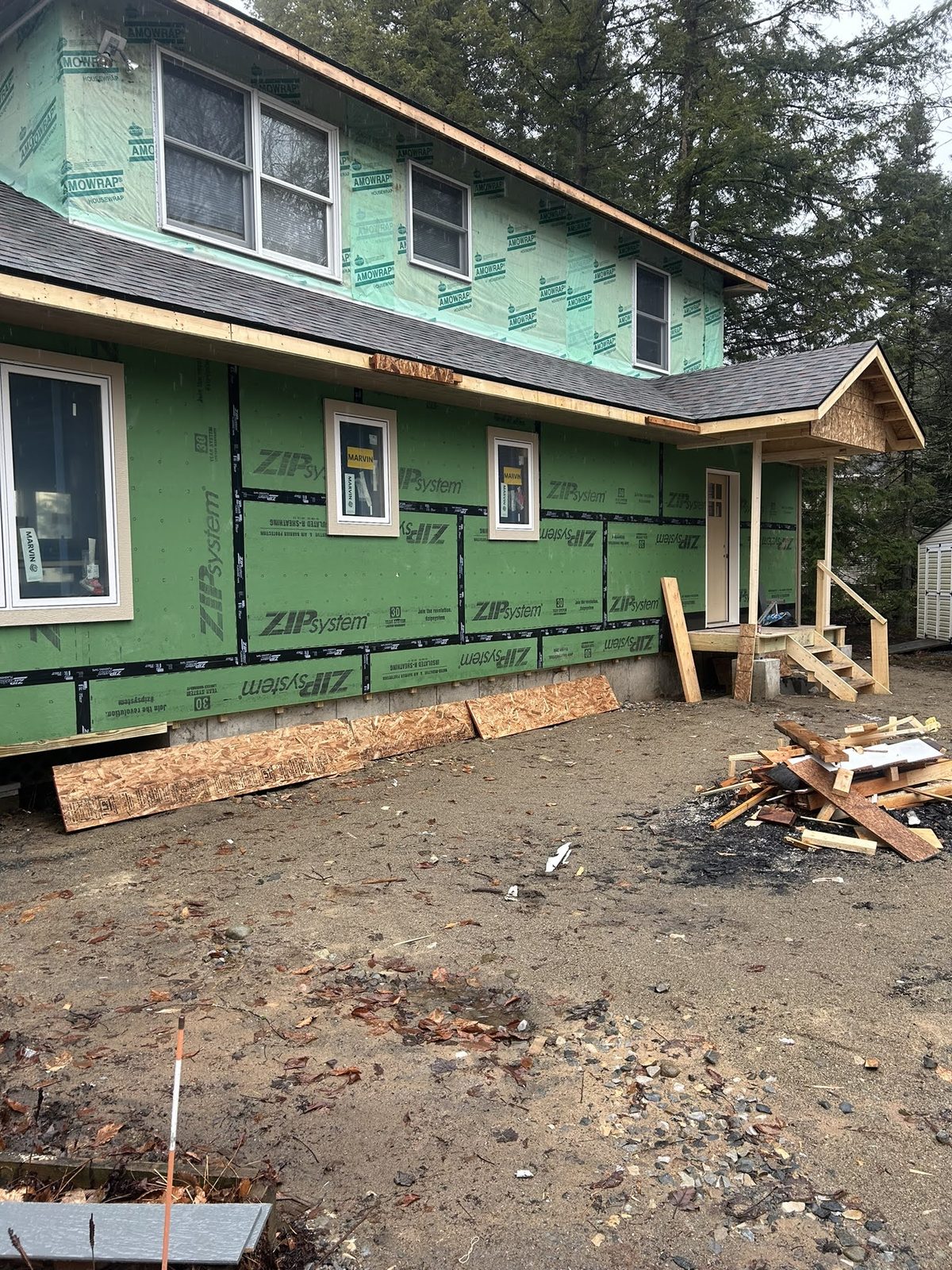 Home exterior with new windows and weather barrier before siding