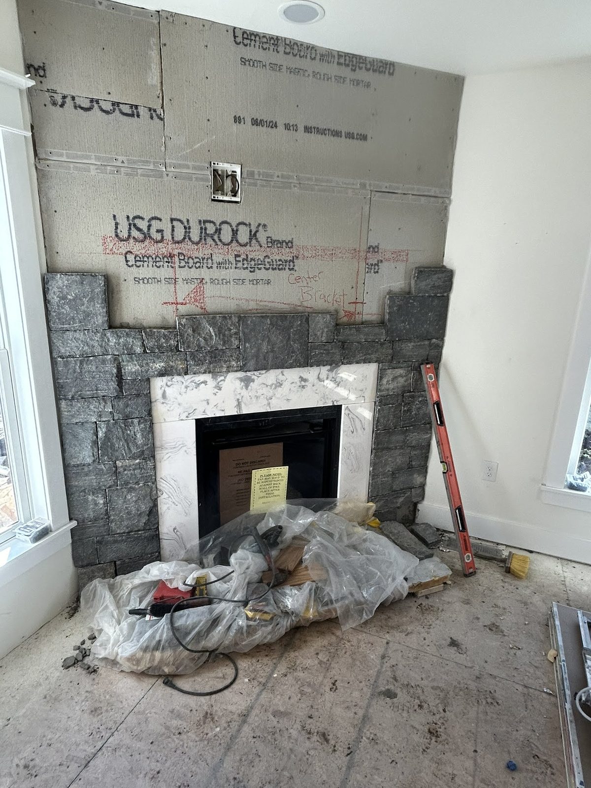 Stone fireplace surround being built during an interior remodel