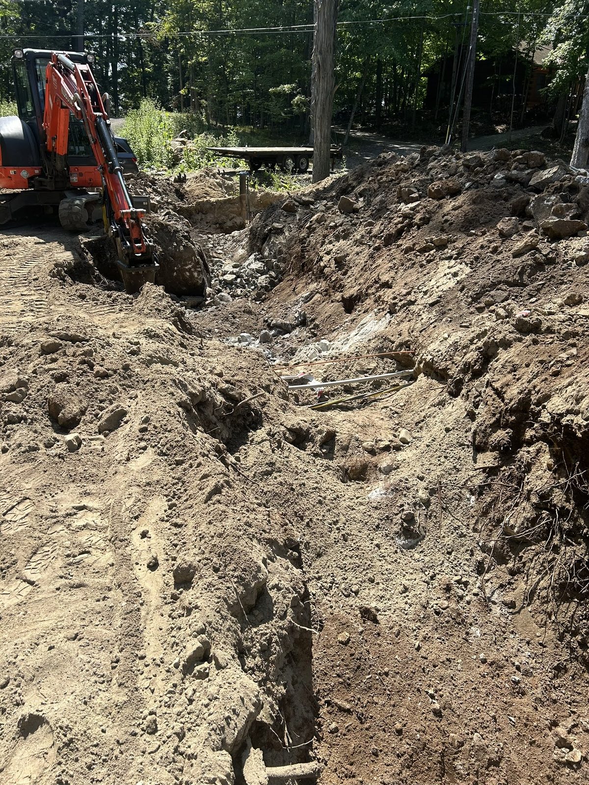 Excavator regrading a Lake George shoreline during site work