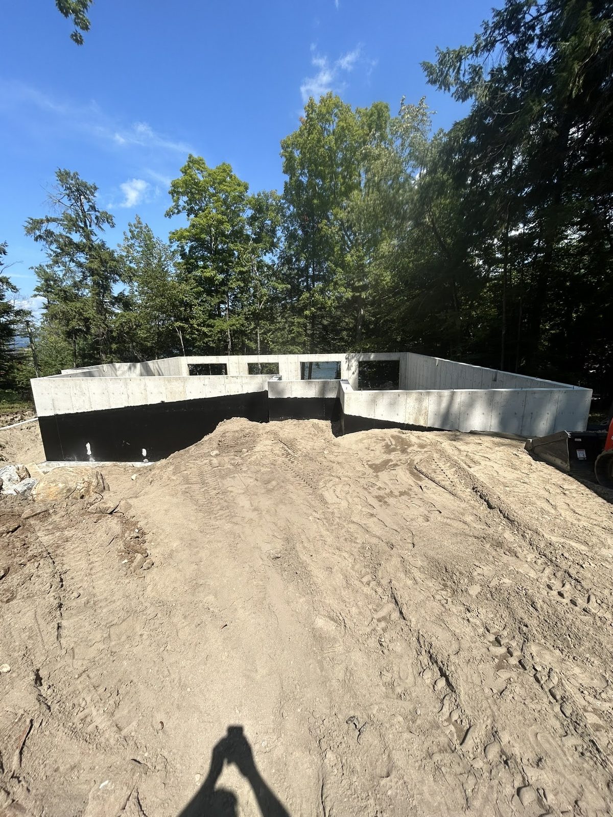 Poured foundation and graded pad at a lakefront build site