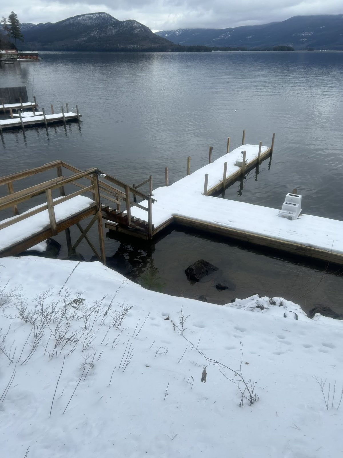 Dock and boathouse edged with ice in midwinter on Lake George