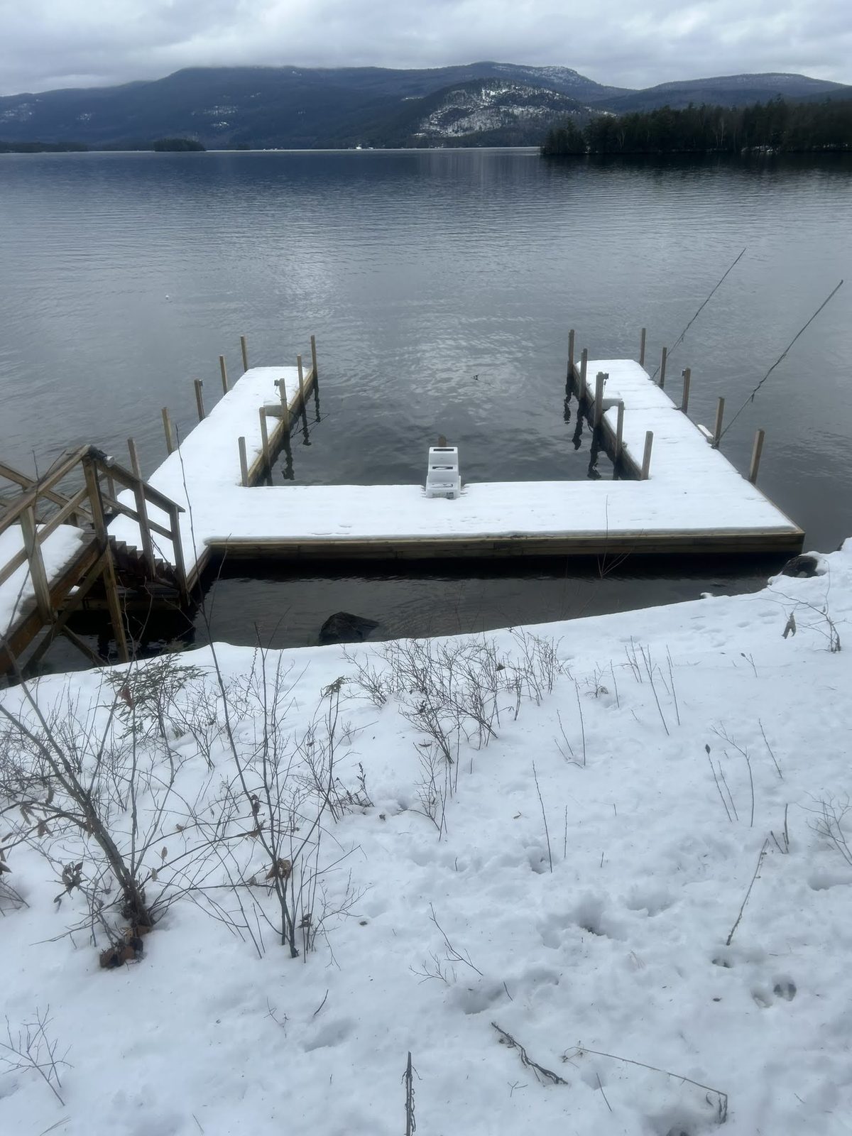 Snow-covered dock and crib system on a frozen Lake George shoreline